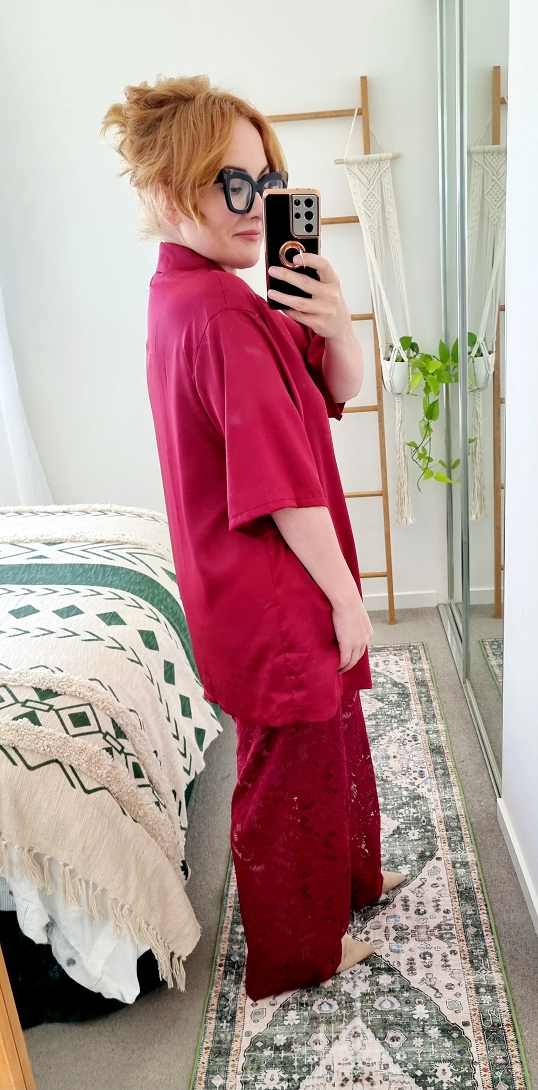 Tegan wearing the Amara Set in Merlot by By Frankie. Oversized satin shirt with statement shell and sun buttons, paired with sheer burgundy lace pants. Tegan is an AU size 10 and wears the Medium.