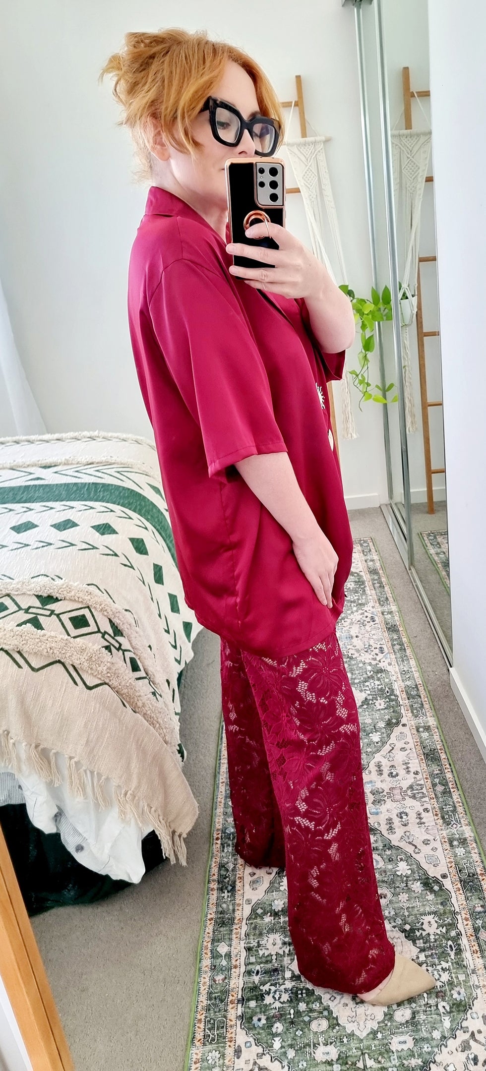 Tegan wearing the Amara Set in Merlot by By Frankie. Oversized satin shirt with statement shell and sun buttons, paired with sheer burgundy lace pants. Tegan is an AU size 10 and wears the Medium.