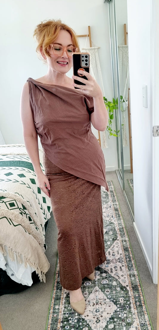 Tegan wearing the Terra Set in Chocolate by By Frankie. The one-shoulder linen top is paired with a coordinating brown lace maxi skirt. Tegan is an AU size 10 and wears the Medium.